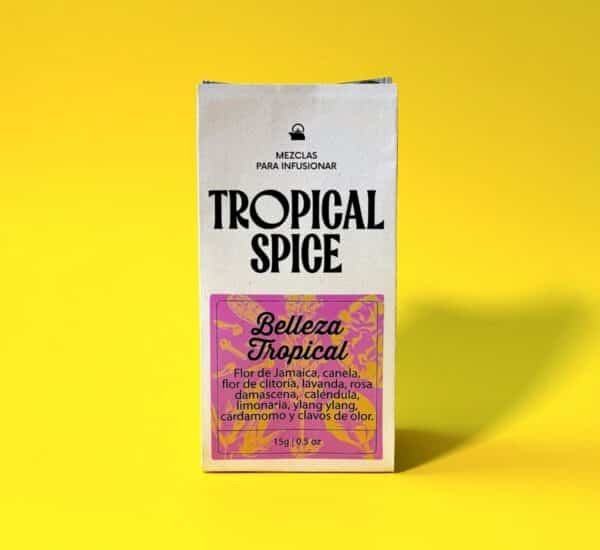 empaque biodegradable de infusión Belleza Tropical de Tropical Spice, mezcla floral con jamaica, clitoria, lavanda, rosa damascena, ylang ylang y especias. Fondo amarillo vivo.
