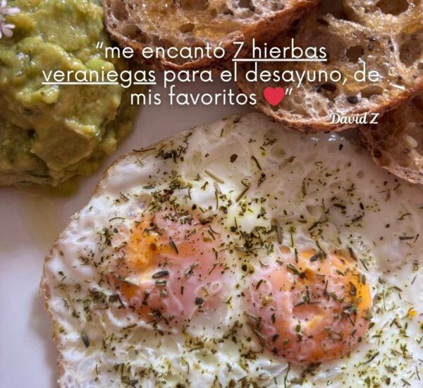 Huevos fritos espolvoreados con 7 hierbas veraniegas acompañados de guacamole y pan artesanal, con una reseña destacando la mezcla "7 hierbas veraniegas" para el desayuno.