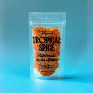 flores de Caléndula de los Andes de Tropical Spice, empacado en bolsa doypack transparente sobre fondo azul degradado.