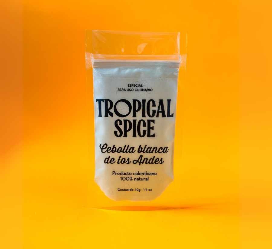 Cebolla blanca de los Andes en polvo de Tropical Spice, empacado en bolsa doypack transparente sobre fondo naranja degradado.