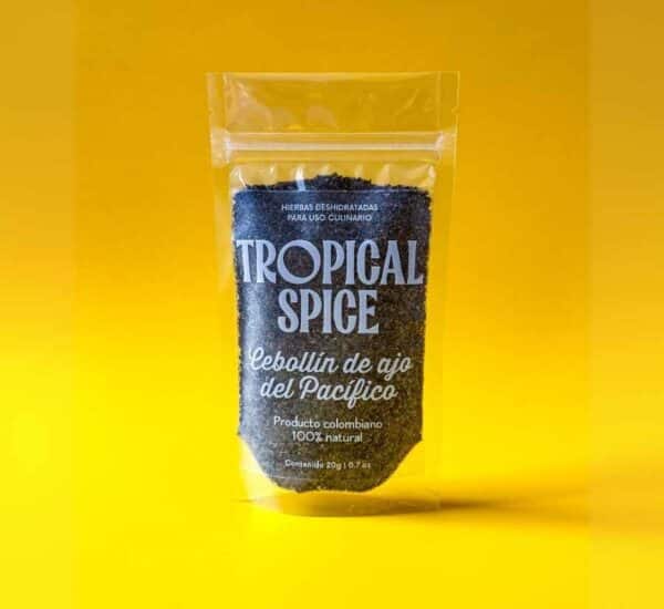 Cebollín de ajo del Pacífico triturado de Tropical Spice, empacado en bolsa doypack transparente sobre fondo amarillo degradado.