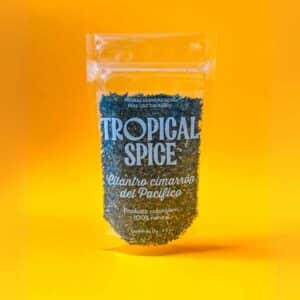 Cilantro cimarrón triturado del Pacífico de Tropical Spice, empacado en bolsa doypack transparente sobre fondo naranja degradado.