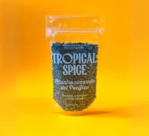 Cilantro cimarrón triturado del Pacífico de Tropical Spice, empacado en bolsa doypack transparente sobre fondo naranja degradado.