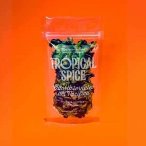 flor de Clitoria ternatea del Pacífico de Tropical Spice, empacado en bolsa doypack transparente sobre fondo naranja degradado.