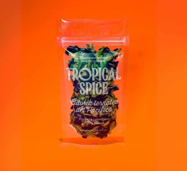 flor de Clitoria ternatea del Pacífico de Tropical Spice, empacado en bolsa doypack transparente sobre fondo naranja degradado.