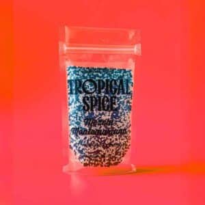 Mezcla Montemariana de ajonjolí negro y blanco del Caribe de Tropical Spice, empacado en bolsa transparente doypack sobre fondo rojo