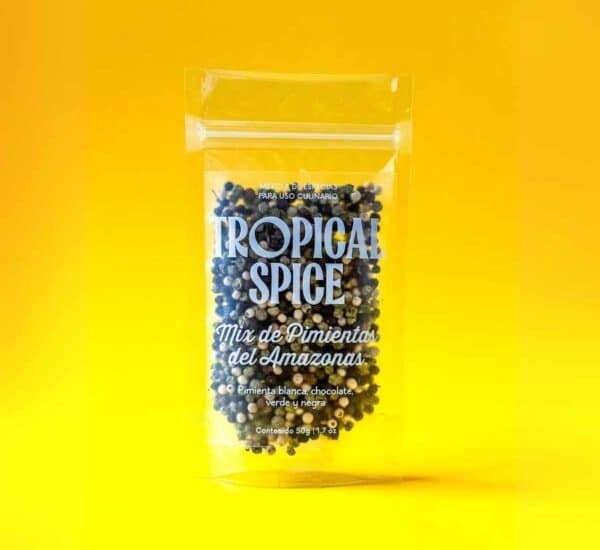 Mix de pimientas en grano del Amazonas de Tropical Spice, empacado en bolsa transparente doypack sobre fondo naranja-amarillo