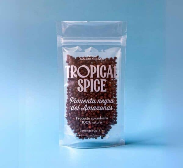Pimienta negra en grano de Tropical Spice, empacado en bolsa transparente doypack sobre fondo azul