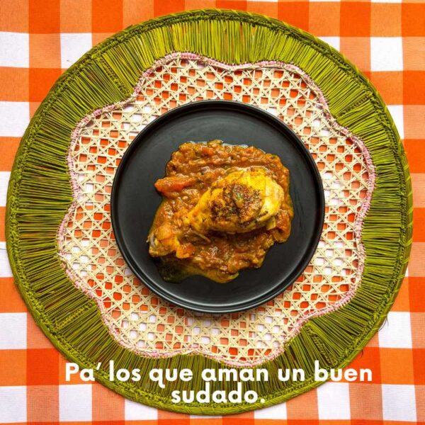 Plato de sudado de pollo criollo con hogao colombiano servido sobre plato negro, ideal para amantes de la cocina tradicional y especias naturales como Cebollín de ajo de Tropical Spice.